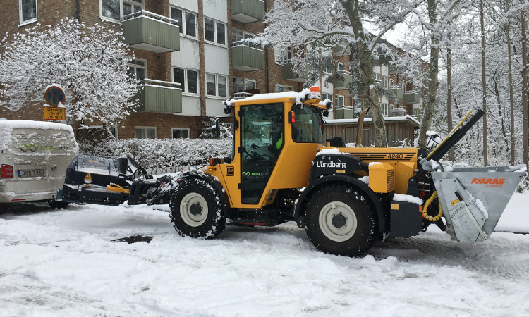 Vår traktor snöröjer gatorna utanför en bostadsförening